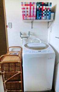 a washing machine with a plate on top of it at 丘の上白亜の洋館風別荘静かな小さなお宿Guest House Itoh 2名様から6名様 in Asahikawa