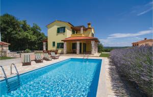 a villa with a swimming pool in front of a house at Holiday Home Kunj Croatia in Kunj