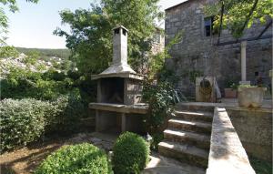 a stone fireplace in the yard of a house at Three-Bedroom Holiday Home In Blato in Blato +24 photos