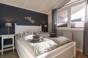 a bedroom with a large bed with pillows on it at Ferienhaus Robbi ⇒ Urlaub am Meer in Wesselburenerkoog