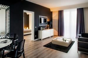 a living room with a table and a living room with a couch at Hotel Da Vinci in Milan