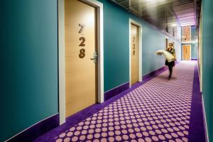 a woman walking down a corridor in a hallway at Hotel Da Vinci in Milan