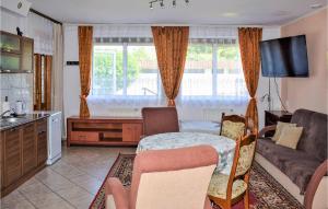 a kitchen and living room with a table and a couch at Cozy Apartment In Ustka With Wifi in Ustka