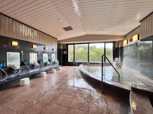 a large bathroom with a tub with sinks and mirrors at ひこさんホテル和 in Hikosan