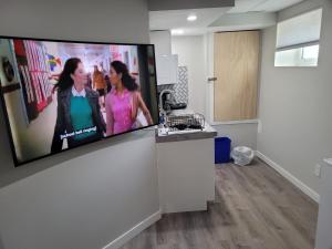 a living room with a flat screen tv on a wall at Winnipeg Radiant Home in Winnipeg