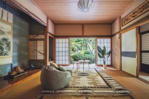 a living room with a couch and a table at 佐渡古民家一棟貸切 Active Art Hotel 日本庭園 佐渡アート in Sado