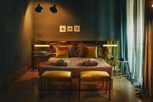 - une chambre avec un grand lit et deux tabourets dans l'établissement Boutique Hotel Borgo Nuovo, à Milan