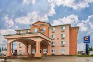 ein Hotelgebäude mit einem Bogen auf einem Parkplatz in der Unterkunft Comfort Inn & Suites in Edson