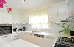 a white kitchen with white cabinets and a sink at Holiday Home Pakostane 25 in Pakoštane