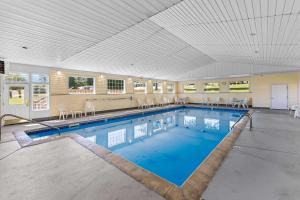 a large swimming pool with chairs and a large ceiling at Quality Inn Lakefront in Saint Ignace