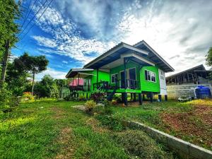 a green house with a blue roof on a yard at Kanitta Homestay kohyaonoi in Ban Bang Chak