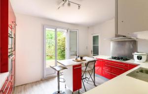 a kitchen with red cabinets and a white counter top at Gorgeous Home In Joué Les Tours in Joue-les-Tours