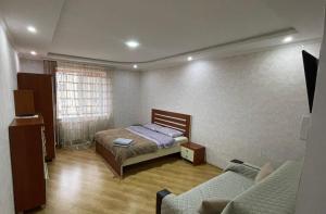 a bedroom with a bed and a couch in it at Квартира возле Автовокзала in Rivne