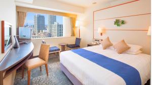a hotel room with a bed and a desk and a window at Premier Hotel Nakajima Park Sapporo in Sapporo