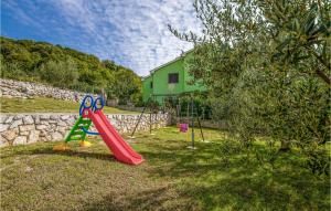 a playground with a red slide in the grass at 2 Bedroom Lovely Apartment In Jurandvor in Jurandvor