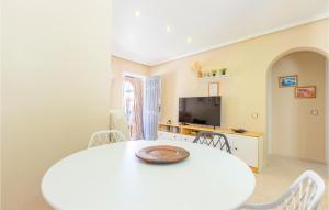 biała jadalnia z białym stołem i krzesłami w obiekcie Cozy Apartment In Torrevieja With Wifi w mieście Torrevieja