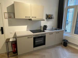 Una pequeña cocina con fregadero y estufa. en Stadsstudio op toplocatie, en Amberes 2 fotos más