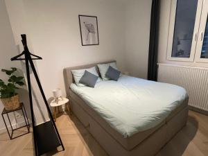 Una cama con dos almohadas encima en una habitación. en Stadsstudio op toplocatie, en Amberes