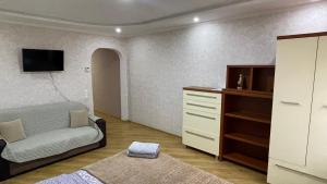 a living room with a bed and a dresser at Квартира возле Автовокзала in Rivne