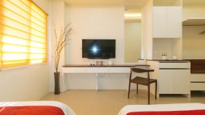 a bedroom with a desk with a tv and a chair at RedDoorz @ Leoncia Apartelle Mandaue City in Mandaue City