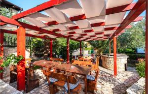 drewniana pergola ze stołami i krzesłami na patio w obiekcie Five-Bedroom Holiday Home In Vir w mieście Vir