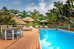 una piscina con mesa, sillas y sombrilla en Akasa Goa, en Palolem