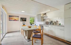 a kitchen with white cabinets and a table and chairs at Stunning Home In Zeulenroda-Triebes in Stelzendorf