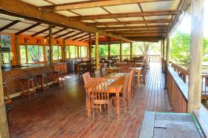a restaurant with wooden tables and chairs on a deck at Hippo Waterfront Lodge in Nelspruit +68 photos