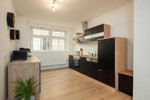 a kitchen with black cabinets and a counter in it at Leipzig Mitte - 2 Parkplätze - Koselig Apartments in Leipzig +11 photos