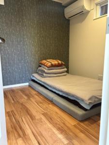a bedroom with a bed with pillows on it at ハーモニー地下鉄幌平橋駅徒歩6分市電行啓通駅2分 in Sapporo