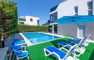 una piscina con sedie e ombrellone accanto a una casa di Stunning Home In Fazana With Sauna a Fažana