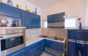 a blue kitchen with blue cabinets and a sink at Two-Bedroom Apartment In Klek in Klek