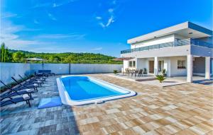 a villa with a swimming pool and a house at 3 Bedroom Stunning Home In Bogomolje in Bogomolje