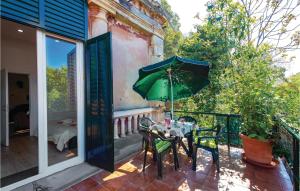 a patio with a table and a green umbrella at Beautiful Apartment In Rijeka With Wifi in Rijeka