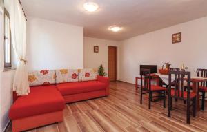 a living room with a red couch and a table at One-Bedroom Apartment In Maslenica in Maslenica +16 photos