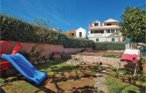 un toboggan bleu dans une cour avec une maison dans l'établissement Three-Bedroom Apartment In Racisce, à Račišće 31 autres photos