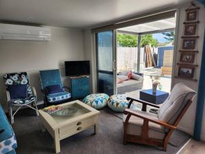 a living room with a couch and a table at #40 Below in Waitarere