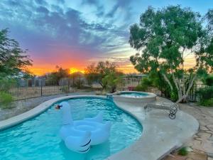 two swans in a pool with a sunset in the background at Lazy H Bar Desert Outpost Ranch House with Pool and Hot Tub in Tucson