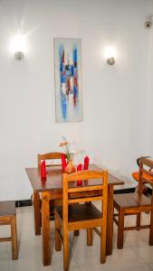 a dining room with a wooden table and chairs at Yash Rest Inn in Negombo