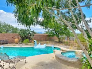 a pool with two rubber swans in a yard at Lazy H Bar Desert Outpost Ranch House with Pool and Hot Tub in Tucson