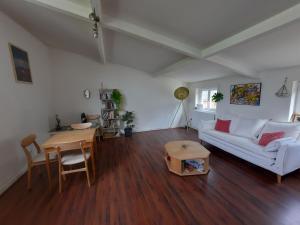 a living room with a white couch and a table at Maisonnette pour halte angevine in Les Ponts-de-Cé
