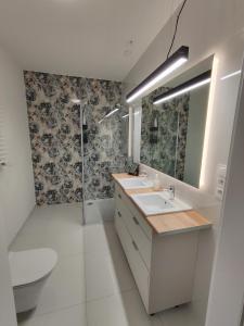 a bathroom with a sink and a toilet and a shower at Apartamenty MM - Nowa Sól in Nowa Sól