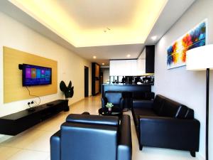 a living room with black leather furniture and a tv at Genting SkyCozyColdInn2R2B AT Ion Delemen in Genting Highlands