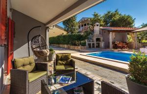 patio con sedie e tavolo accanto alla piscina di Holiday Home Pavicini 26 a Veliki Vareški
