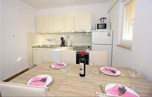 a kitchen with a table with a bottle of wine at Lovely Home In Supetar in Supetar