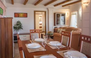 a dining room with a table with plates and wine glasses at Two-Bedroom Apartment In Komarna in Klek