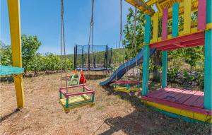 a playground with a slide and a swing at Holiday Home Mravnica 09 in Mravnica
