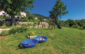 a blue tub sitting in the grass next to a playground at Gorgeous Home In Moscenicka Draga in Martina