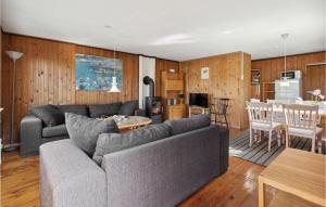 a living room with a couch and a table and a kitchen at Holiday Home Rønnemose Sydals Denm in Skovby