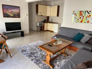 a living room with a couch and a table at Ourania's Apartment Kastoria in Mavrokhórion